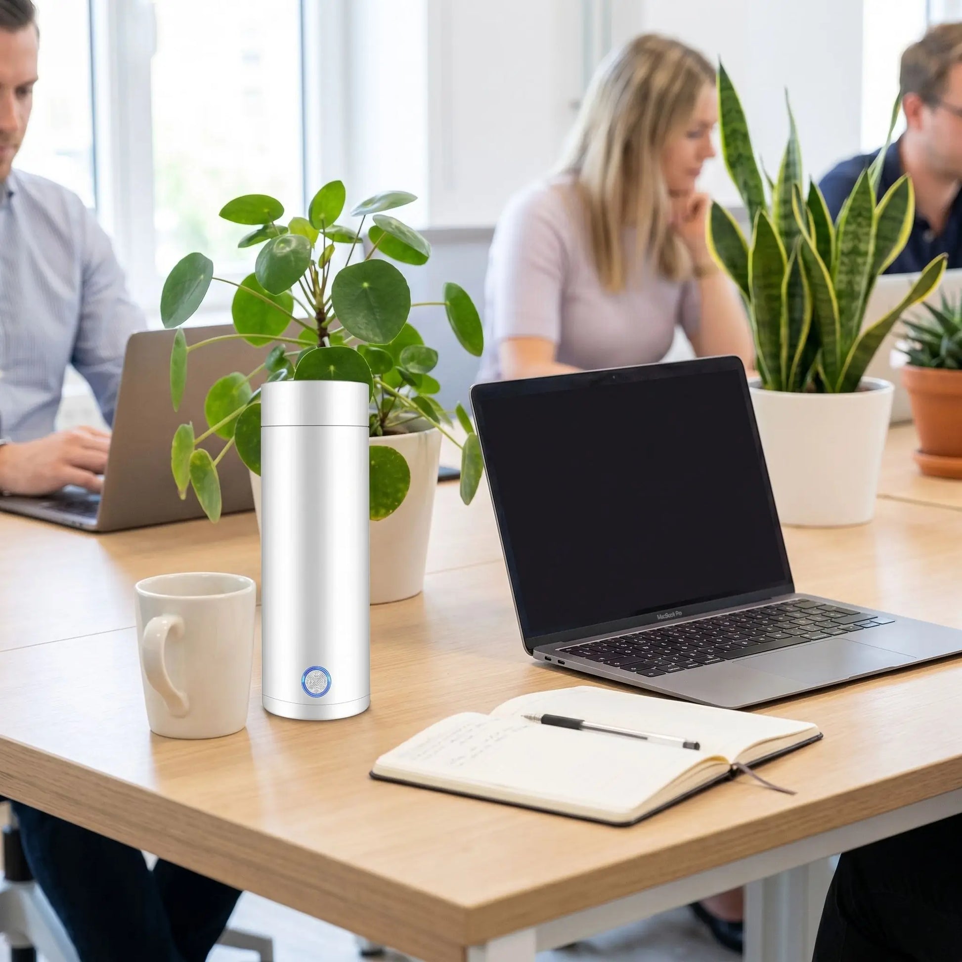 Mini bouilloire de voyage utilisée par une femme au bureau avec ordinateur portable