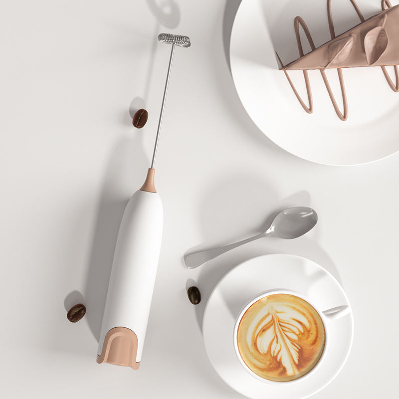 Mousseur à Lait électrique rose créant un dessin latte art dans une tasse