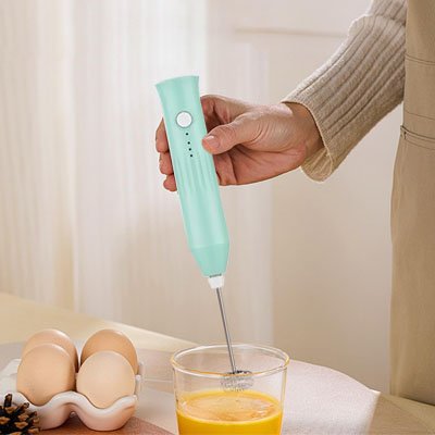 Mousseur à Lait électrique turquoise utilisé pour préparer une boisson mousseuse