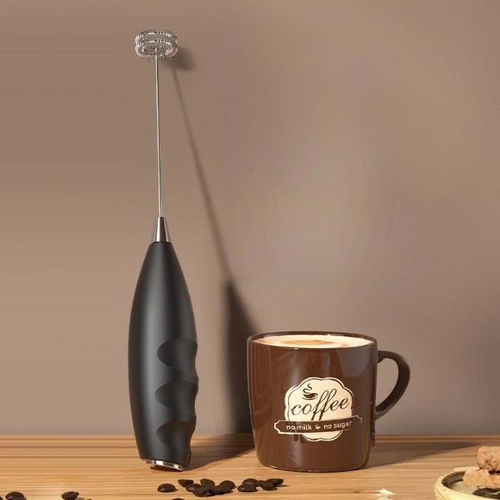 Mousseur de Lait portable argenté et noir sur plan de travail en bois